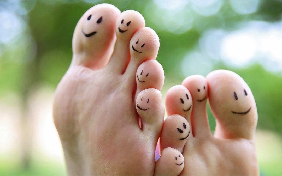 bare feet with smiley faces drawn on toes